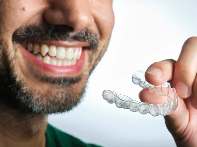 Zahnschienen eignen sich für alle, die gerade Zähne haben wollen. Egal, ob jung oder alt. Mann mit Zahnschiene lacht.